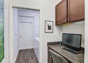 Thumbnail 20 of 53 - A room with a desk and a computer monitor at Sovereign at Overland Park Apartments, Overland Park, KS