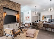 Thumbnail 9 of 50 - A modern living room with a stone wall and a flat screen TV.