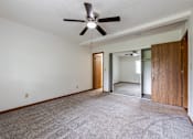 Thumbnail 45 of 50 - A room with a ceiling fan and carpeted floor.