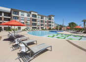 Thumbnail 4 of 24 - Exterior of apartments with loungers by pool