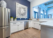 Thumbnail 28 of 40 - A modern kitchen with a stainless steel refrigerator and white cabinets at Waterstone at Cinco Ranch Apartments, Texas, 77450
