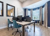 Thumbnail 31 of 40 - A room with a desk, chairs, and a mirror at Waterstone at Cinco Ranch Apartments, Texas, 77450