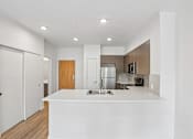 Thumbnail 47 of 59 - A modern kitchen with white countertops and wooden accents.