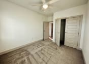 Thumbnail 32 of 46 - an empty living room with a ceiling fan and a closet