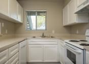 Thumbnail 4 of 36 - Three Bedroom | Kitchen with white cabinets and white appliances.
