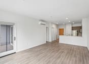 Thumbnail 44 of 59 - A spacious room with a sliding glass door and wood flooring.
