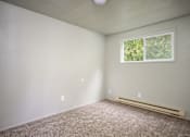 Thumbnail 11 of 22 - A room with a window and a carpeted floor.