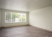 Thumbnail 7 of 22 - A room with a window and wooden flooring.