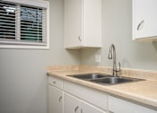 Thumbnail 22 of 22 - A kitchen with a sink and cabinets.
