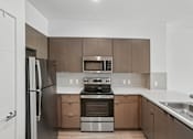 Thumbnail 46 of 59 - A modern kitchen with a stainless steel refrigerator and oven.