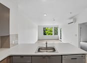 Thumbnail 43 of 59 - A modern kitchen with a large sink and a window.