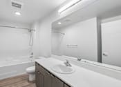 Thumbnail 59 of 59 - A white bathroom with a toilet, sink, and shower.