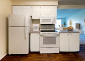 Thumbnail 3 of 30 - a kitchen with white cabinets and appliances and a white refrigerator