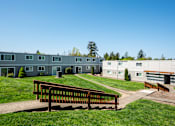 Thumbnail 12 of 25 - The Scholls Apartments Grass courtyard with stairs, paths and view of exterior apartment building