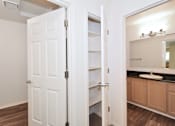 Thumbnail 12 of 24 - A white door is open to a bathroom with a sink and mirror.