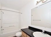 Thumbnail 18 of 24 - A white bathroom with a toilet, sink, and bathtub.