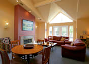 Thumbnail 24 of 24 - A living room with a fireplace and a painting on the wall.