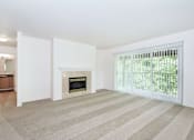 Thumbnail 6 of 24 - A living room with a fireplace and striped carpet.