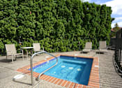 Thumbnail 20 of 24 - A small pool surrounded by a brick border and a table and chairs.