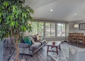Thumbnail 10 of 56 - a living room with a couch and a table and a tree