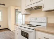 Thumbnail 50 of 56 - A white stove and oven in a kitchen with a fan on the ceiling.