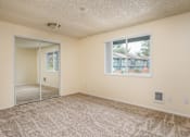 Thumbnail 54 of 56 - A room with a carpeted floor, a window, and a sliding glass door.