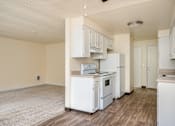 Thumbnail 51 of 56 - A kitchen with white appliances and wooden floors.
