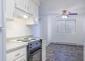 Thumbnail 17 of 56 - a kitchen with white cabinets and a stove and a ceiling fan