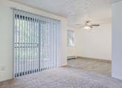 Thumbnail 20 of 56 - an empty living room with a large window and a ceiling fan