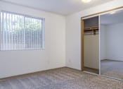 Thumbnail 22 of 56 - an empty bedroom with a large window and a mirrored closet