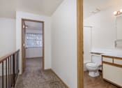 Thumbnail 36 of 56 - a renovated bathroom with a toilet and a sink in a room with a hall way