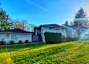 Thumbnail 7 of 26 - A house with a green lawn in front of it.