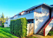 Thumbnail 6 of 26 - A house with a red staircase and a green lawn.
