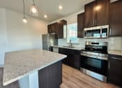 Thumbnail 24 of 46 - a kitchen with a granite counter top and stainless steel appliances