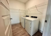 Thumbnail 29 of 46 - a laundry room with two washes and a dryer in it