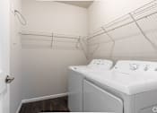 Thumbnail 6 of 48 - a laundry room with a washer and dryer and a closet with a rack