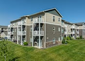 Thumbnail 12 of 48 - an exterior view of an apartment building with a green lawn