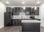 Thumbnail 1 of 48 - an empty kitchen with black appliances and dark wood cabinets