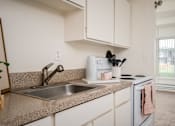 Thumbnail 21 of 26 - A kitchen with a sink, a toaster, and a window.