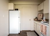 Thumbnail 20 of 26 - A white refrigerator stands in a kitchen with a white door.