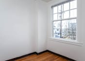 Thumbnail 7 of 52 - A room with a window and a wooden floor.