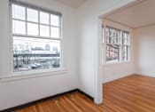 Thumbnail 6 of 52 - A room with a large window and a wooden floor.