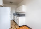 Thumbnail 13 of 52 - A kitchen with white cabinets and a patterned floor.