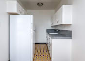 Thumbnail 11 of 52 - A kitchen with white appliances and cabinets.