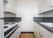 Thumbnail 10 of 52 - A kitchen with white cabinets and a black stove top oven.