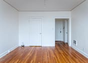 Thumbnail 12 of 52 - A room with wooden floors and two white doors.