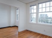 Thumbnail 8 of 52 - A room with a large window and wooden floors.