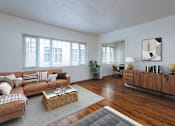 Thumbnail 2 of 52 - A living room with a brown couch, a coffee table, and a wooden cabinet.
