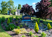 Thumbnail 49 of 50 - A garden with a sign that says "HAVEN" in front of a house.