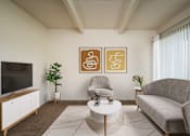 Thumbnail 18 of 26 - A living room with a grey couch, a white coffee table, a television, and two framed artworks on the wall.